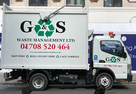 a garbage truck parked in front of a building